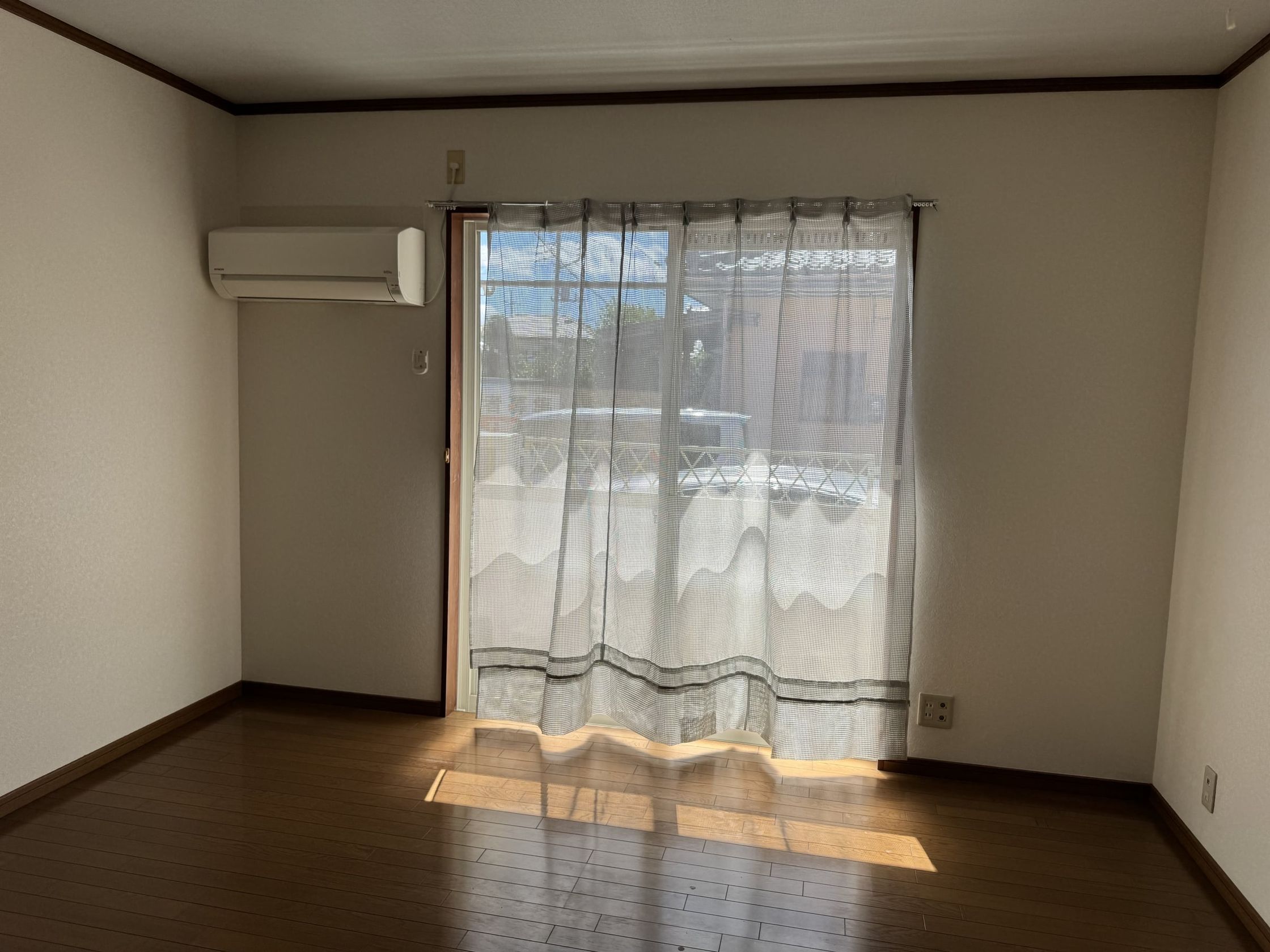 明るい窓のある居室。エアコン付き、床はフローリング